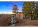 Outdoor potting shed with large windows and artistic statue in a natural setting with distant views at 7645 Fox Creek Trl, Franktown, CO 80116