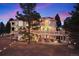 Exterior elevation of home featuring multiple stories, balconies, string lights, and brick detailing at 7645 Fox Creek Trl, Franktown, CO 80116