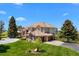 Charming two-story home featuring a tile roof, brick accents, and lush lawn at 7645 Fox Creek Trl, Franktown, CO 80116