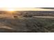 Distant aerial view of a large property showing rolling hills and a distant home at sunset at 7645 Fox Creek Trl, Franktown, CO 80116