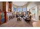 Elegant living room features a cozy fireplace and scenic views through large windows at 7645 Fox Creek Trl, Franktown, CO 80116