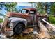 Rustic outdoor display with vintage truck, rock feature, and cascading water under mature trees at 7645 Fox Creek Trl, Franktown, CO 80116