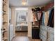 Walk-in closet with custom shelving, built-in drawers, laundry, and access to the bedroom, offering ample storage and organization at 1475 Delgany St # 307, Denver, CO 80202