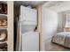 Convenient laundry area with stacked washer and dryer, as well as open shelving for storage, maximizing space and functionality at 1475 Delgany St # 307, Denver, CO 80202
