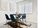Modern dining room with glass table, blue chairs, and minimalist decor at 180 S Nome St, Aurora, CO 80012