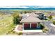Aerial view of home with clay tile roof, attached garage and mature landscaping at 8611 Coachlight Way, Littleton, CO 80125