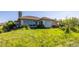 A grassy backyard with a stone chimney, patio and lovely greenery at 8611 Coachlight Way, Littleton, CO 80125