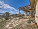 Home with a large stone patio under a pergola and a view of the fenced backyard at 8611 Coachlight Way, Littleton, CO 80125