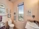 Bathroom featuring a toilet, sink and countertop, window with a view, and wall art at 8611 Coachlight Way, Littleton, CO 80125