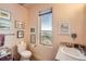 Powder room with toilet and sink with tile countertops, window with mountain views, and art on the wall at 8611 Coachlight Way, Littleton, CO 80125