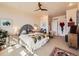 Light filled bedroom featuring a ceiling fan, unique artwork, and view to the en-suite bathroom at 8611 Coachlight Way, Littleton, CO 80125