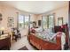 Bedroom featuring two large windows, wood furniture, and warm tones at 8611 Coachlight Way, Littleton, CO 80125