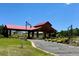 Community entrance features a red metal roof, a wooden archway, and professional landscaping at 8611 Coachlight Way, Littleton, CO 80125