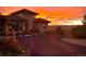 Home exterior with a circular driveway against a vibrant sunset backdrop at 8611 Coachlight Way, Littleton, CO 80125