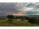 Home nestled in a serene landscape under a dramatic, cloudy sky at 8611 Coachlight Way, Littleton, CO 80125
