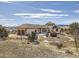 Expansive stucco house with a circular driveway and beautiful views, set in a natural landscape at 8611 Coachlight Way, Littleton, CO 80125