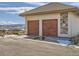 Attached two car garage with adjacent stone facade and mountain views at 8611 Coachlight Way, Littleton, CO 80125