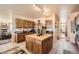 Open kitchen with a central island, custom wood cabinets, and modern appliances at 8611 Coachlight Way, Littleton, CO 80125