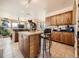 Open concept kitchen featuring natural wood cabinets, center island and modern lighting at 8611 Coachlight Way, Littleton, CO 80125