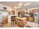 Well-equipped kitchen featuring a central island, wood cabinets, and modern stainless steel appliances at 8611 Coachlight Way, Littleton, CO 80125