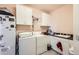 Bright laundry room with modern white cabinets, sink and appliances at 8611 Coachlight Way, Littleton, CO 80125