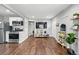Open concept living area with hardwood floors, a large TV, and a stainless steel oven at 1010 S Osceola St, Denver, CO 80219