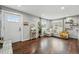 Bright living room features hardwood floors, a cozy couch, decor shelving, and an inviting front door at 1010 S Osceola St, Denver, CO 80219