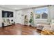 Comfortable living room with hardwood floors, a cozy couch, decor shelving, and a large TV at 1010 S Osceola St, Denver, CO 80219