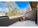 Cozy balcony featuring a chair, side table, and relaxing views of the neighborhood trees at 409 Terry St # D, Longmont, CO 80501