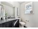Elegant powder room with granite vanity, modern fixtures, and a decorative mirror at 409 Terry St # D, Longmont, CO 80501