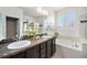 Elegant bathroom with double vanity, a soaking tub, and a tiled shower at 9080 Fig St, Arvada, CO 80005