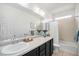 Bright bathroom featuring a tub with shower, white cabinets, and neutral countertop at 9080 Fig St, Arvada, CO 80005