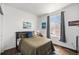 Bedroom featuring hardwood floors, a large window with grey curtains, and a cozy queen sized bed at 9080 Fig St, Arvada, CO 80005