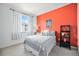 Bright bedroom with an accent wall, a plush patterned bed, and a sunlit window at 9080 Fig St, Arvada, CO 80005