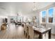 Bright dining room featuring a modern chandelier, hardwood floors, large windows and slider door to backyard at 9080 Fig St, Arvada, CO 80005