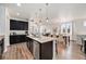 Open kitchen featuring a granite island, stainless steel appliances, dark cabinetry and hardwood floors at 9080 Fig St, Arvada, CO 80005