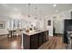 Spacious kitchen featuring a granite island, stainless steel appliances, and open-concept dining area at 9080 Fig St, Arvada, CO 80005