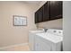 Bright laundry room with neutral-toned walls and cabinets, plus modern washer and dryer at 9080 Fig St, Arvada, CO 80005