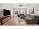 Bright living room featuring hardwood floors, a ceiling fan, a modern TV stand and access to the backyard at 9080 Fig St, Arvada, CO 80005