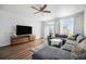 Bright living room with a comfortable gray sofa, light wood flooring, and a ceiling fan at 9080 Fig St, Arvada, CO 80005