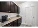 Mud Room featuring granite countertops, dark cabinetry, a coffee station and access to the garage at 9080 Fig St, Arvada, CO 80005