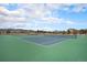 A vibrant green and blue tennis court offers a recreational amenity within a residential community under a partly cloudy sky at 9080 Fig St, Arvada, CO 80005