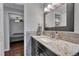 Bathroom vanity with stone countertop and framed mirror leading to the bedroom at 8032 Lee Ct, Arvada, CO 80005