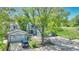 Charming blue house surrounded by mature trees, with a well-maintained lawn and inviting curb appeal at 8032 Lee Ct, Arvada, CO 80005