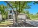 Two-story home with an attached garage, landscaped yard, and mature trees at 8032 Lee Ct, Arvada, CO 80005