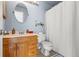 Standard bathroom featuring a shower, toilet, wood cabinets, and a rounded mirror at 338 Pheasant Run, Louisville, CO 80027
