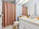 Well-lit bathroom with a white vanity, framed mirror, and shower with a patterned curtain at 338 Pheasant Run, Louisville, CO 80027