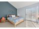 Bright bedroom with a sloped wall, full size bed, and sliding glass door for natural light at 338 Pheasant Run, Louisville, CO 80027