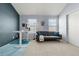 Bright bedroom featuring a comfortable gray sofa, standing desk, and modern decor at 338 Pheasant Run, Louisville, CO 80027