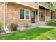 Charming brick townhome with green lawn and landscaped front yard, showcasing curb appeal at 338 Pheasant Run, Louisville, CO 80027